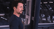 a man with a beard is wearing a black shirt that says ' iron man ' on the front