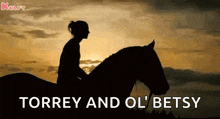 a silhouette of a woman riding a horse at sunset with the words torrey and ol ' betsy written below her .