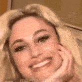 a close up of a woman 's face with her hand on her face .