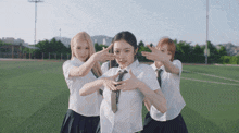 three girls wearing school uniforms and ties are posing for a picture