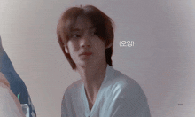 a young man with a white shirt on is looking at the camera with a caption that says ' honey '