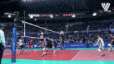 a volleyball game is being played in a stadium that has quezon city written on the side