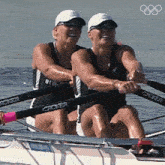 two women are rowing a boat with the word crocker on the handles