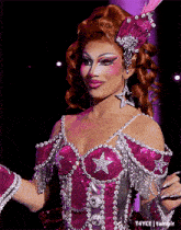a woman in a pink and silver dress with a star on the chest