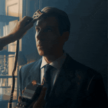 a man in a suit and tie is being shaved