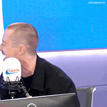 a man sitting in front of a capital microphone