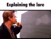 a man is pointing at a blackboard and explaining the lore