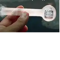 a person is holding a glass pipe with fox news written on it .
