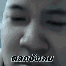 a close up of a person 's face with a foreign language sticker on it