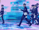 a group of men are dancing on a stage with a pink background