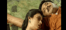 a man and a woman are laying on the floor with their heads on each other .