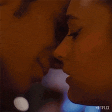 a close up of a man and a woman kissing each other .