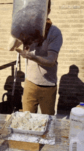 a man pouring liquid into a tray with a pitcher that says all purpose
