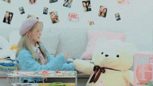 a little girl playing with a teddy bear in a bedroom