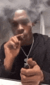 a man is smoking a cigarette while holding a lighter in his hand .