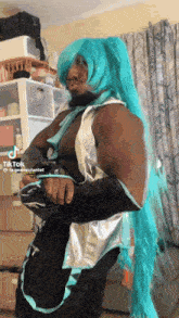 a man with a beard is wearing a blue wig and a silver outfit .