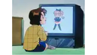 a boy in a plaid shirt is sitting in front of a television