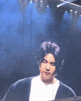 a close up of a man 's face on a stage with a blue background .