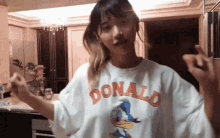 a woman wearing a donald duck t-shirt is dancing