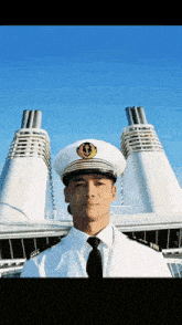 a man wearing a white hat and tie stands in front of a large building