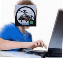 a person is typing on a laptop with a picture of a helicopter in front of their face