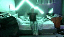 a person is standing on a bed with a laptop on their lap