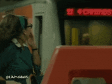 a woman is standing in front of a red sign that says 21