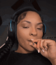 a woman wearing headphones is holding a cigarette in her hand .
