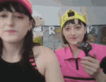 two women are standing next to each other and one has a yellow hat on