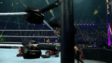 a wrestling match is going on in a ring with a rope hanging from the ropes