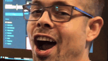 a man wearing glasses is making a funny face with his mouth open