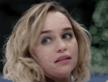 a close up of a woman 's face with a surprised look on her face