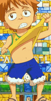 a boy in a yellow shirt and blue shorts is standing in front of a wall