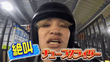 a man wearing a helmet with chinese writing on the bottom right