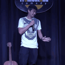 a man stands in front of a sign that says " comedy "