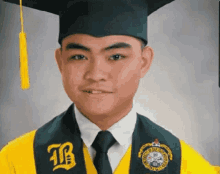 a man wearing a graduation cap and gown with the letter b on the sash