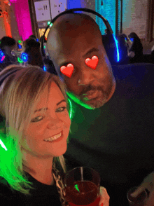 a man and a woman wearing headphones and hearts on their eyes