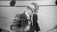 a man in a suit and tie is playing a drum set