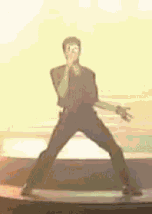a man is singing into a microphone on a stage while dancing .
