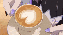 a person with purple nails is holding a cup of cappuccino with a heart shaped foam