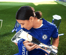 a woman wearing a blue shirt with the word chelsea on it