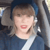 a woman wearing a blue hat and a blue shirt is sitting in a car .
