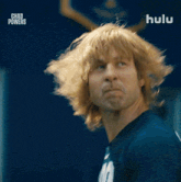 a man with long blonde hair is wearing a shirt that says 200