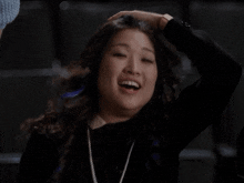 a woman with long hair is making a funny face in a dark room