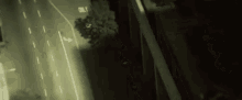 a car is driving down a highway at night in a dark city .