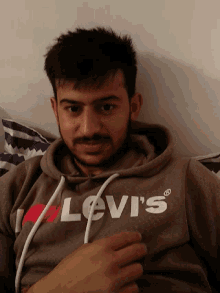 a man wearing a levi 's hoodie is laying down
