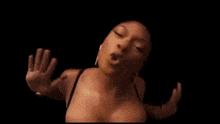 a close up of a woman 's face with her eyes closed and her hands outstretched .