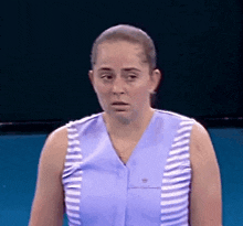 a woman in a blue and white striped shirt is making a funny face