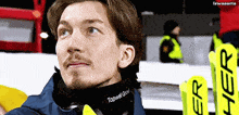 a man wearing a neck warmer that says ' topwell group ' on it