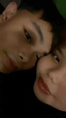 a man and a woman are touching their foreheads